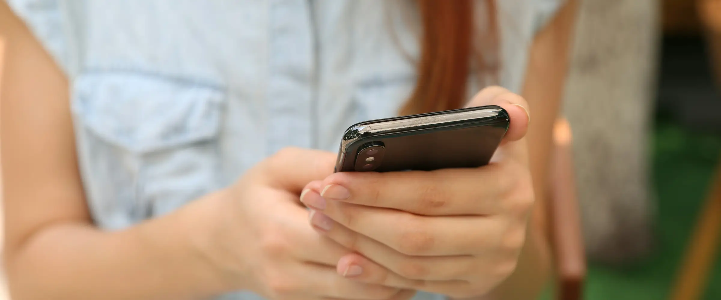 Pessoa segurando um celular com as duas mãos