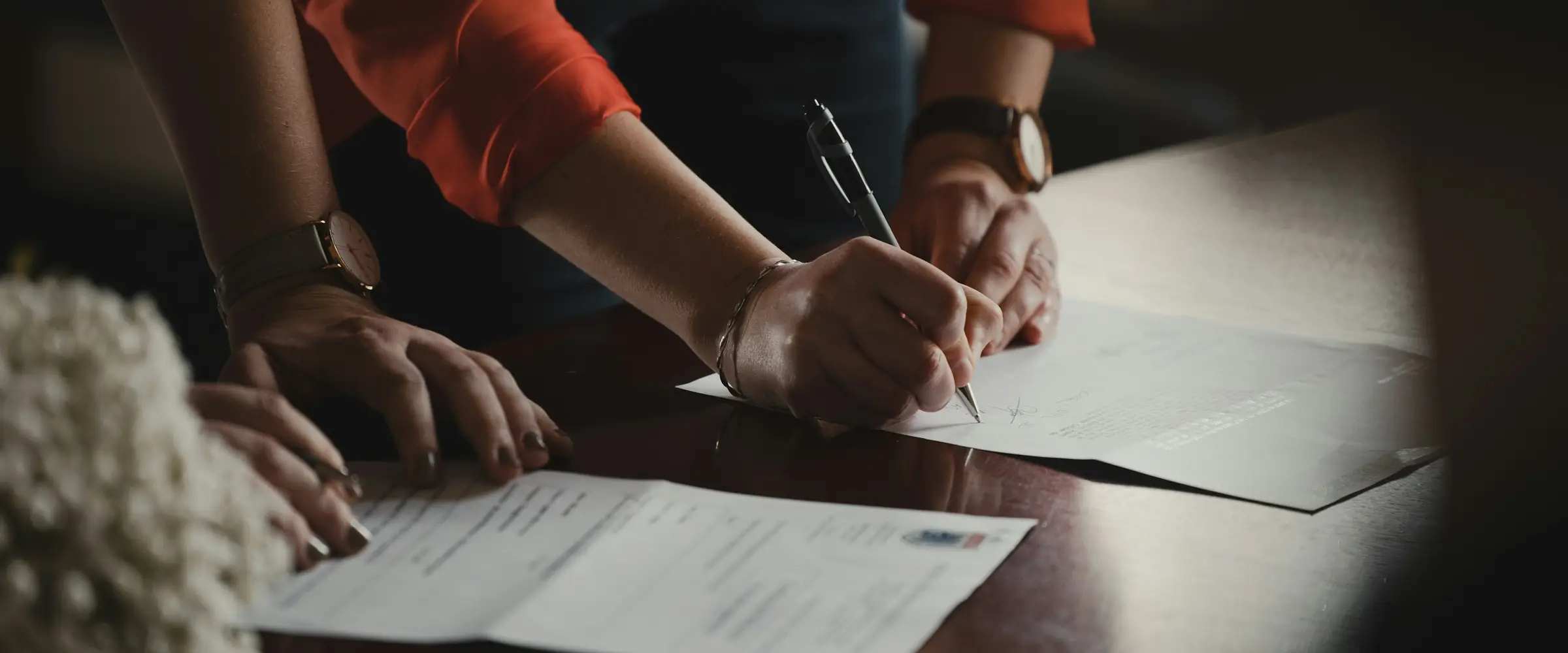 Duas pessoas revisando documentos sobre uma mesa