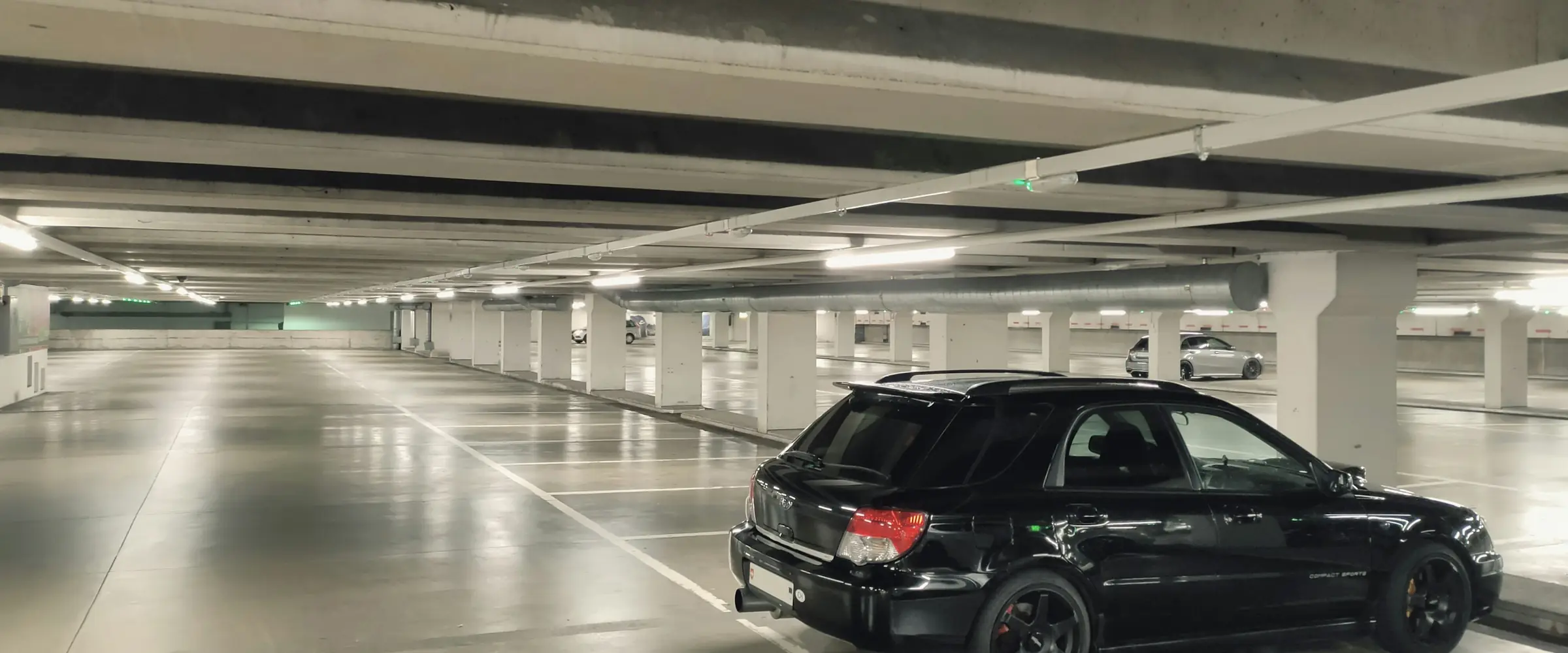 Garagem coberta de edifício com um carro estacionado