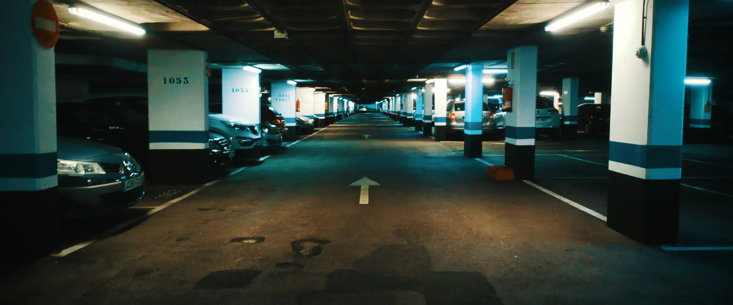 Garagem subterrânea com carros nas vagas numeradas