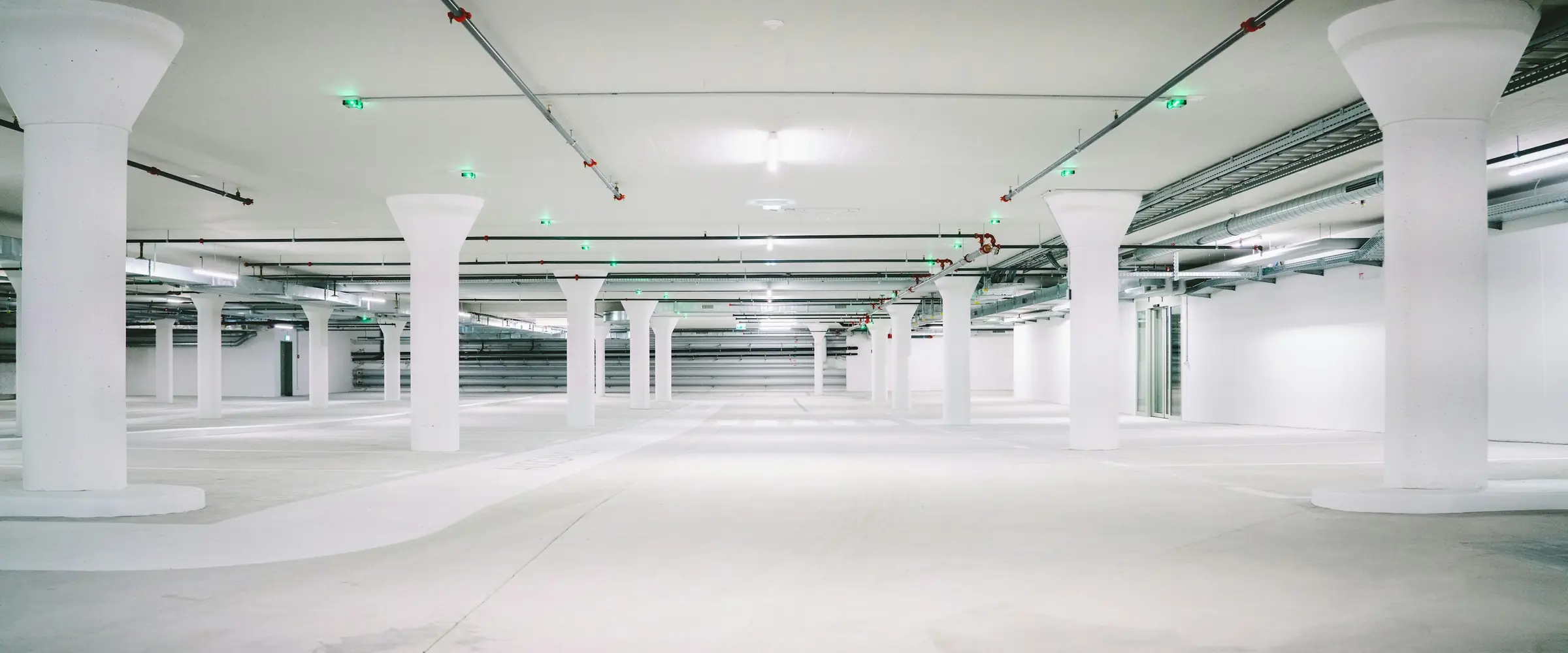 Garagem subterrânea vazia, com colunas brancas
